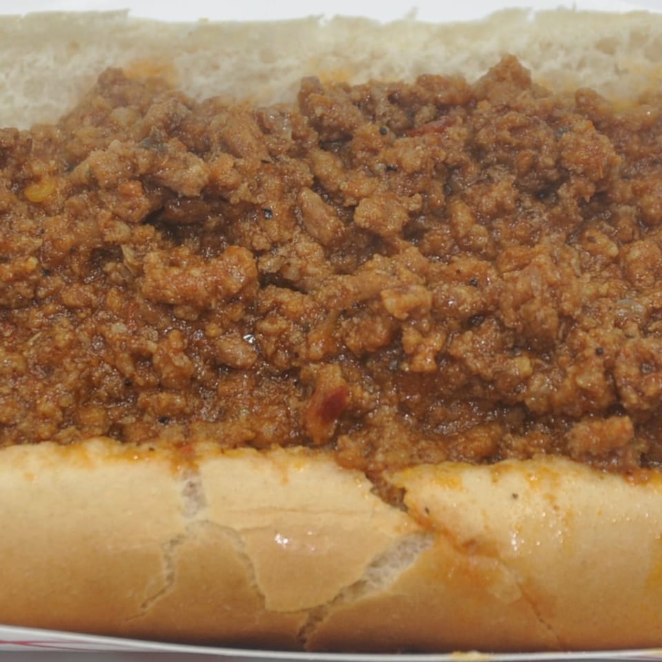 Close-up of a Texas Ranger sloppy joe sandwich, with seasoned ground beef overflowing a bun.
