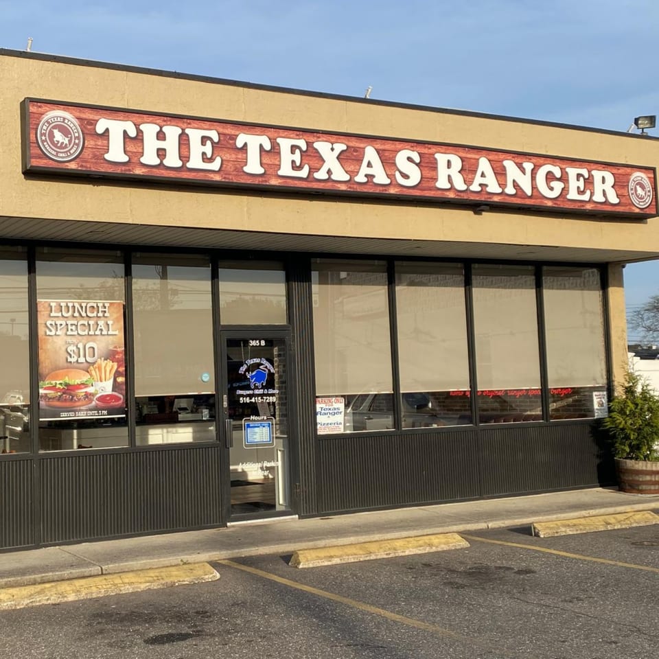 Exterior of The Texas Ranger burger restaurant with a large sign and a lunch special poster.