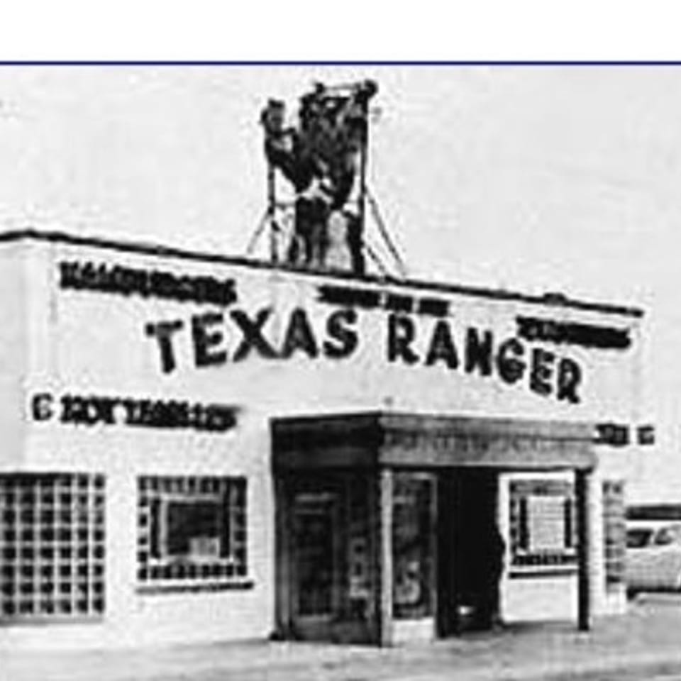 Black and white photo of the historic Texas Ranger burger restaurant building with a rooftop sign.