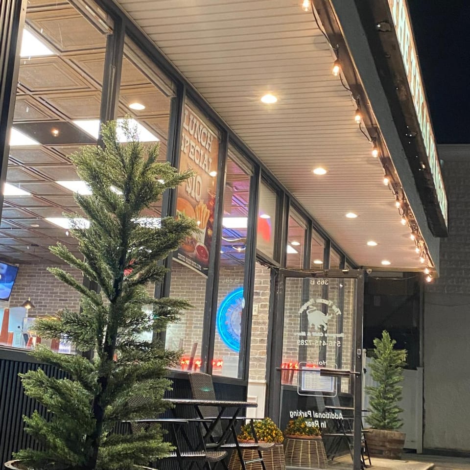 The Texas Ranger burger restaurant exterior at night, with outdoor seating and string lights.